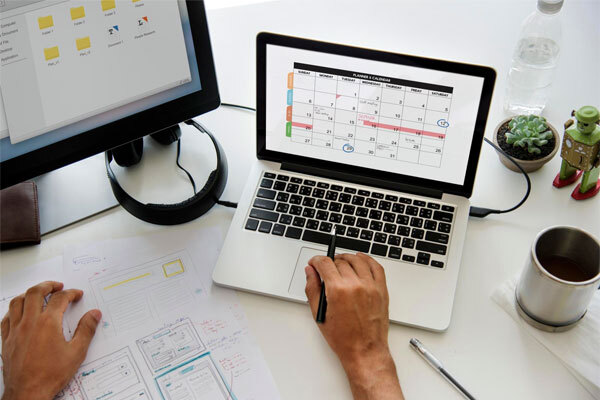 Image of a person working at a desk with their computer