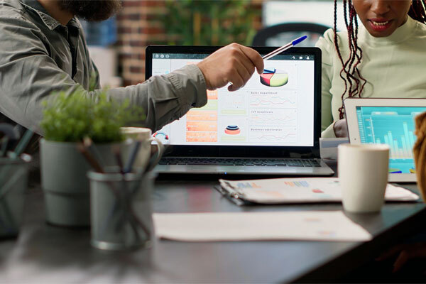 Image of people analyzing website data and digital marketing metrics on a laptop