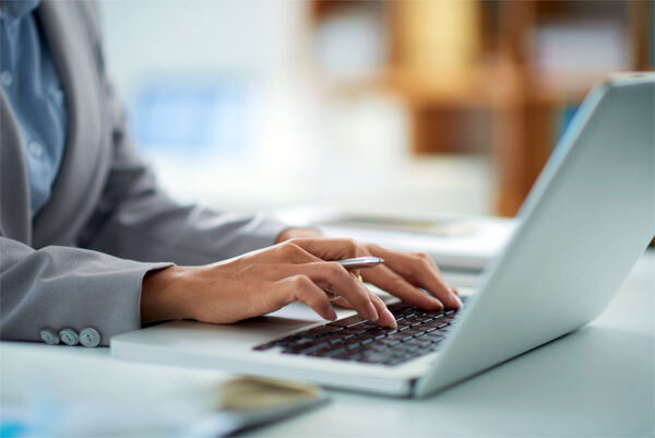 image of a person working on a laptop at an office desk